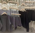 Woman wearing a loose grey knitted long sleeve sweater and matching wide-leg shorts set, front and back view.