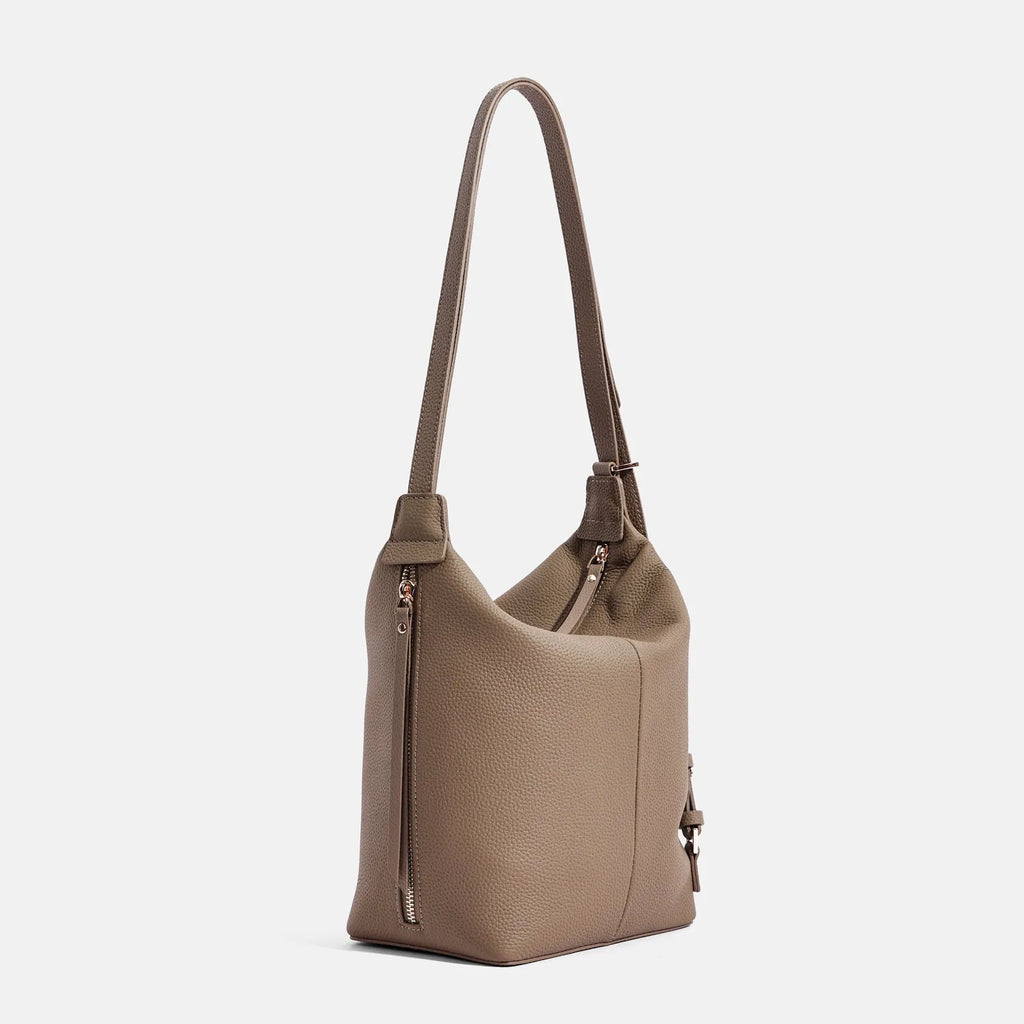 Women's large grey genuine leather bucket bag with a soft handle on a casual outfit.