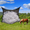 Black woven grid horse feeding bag hanging, filled with hay.