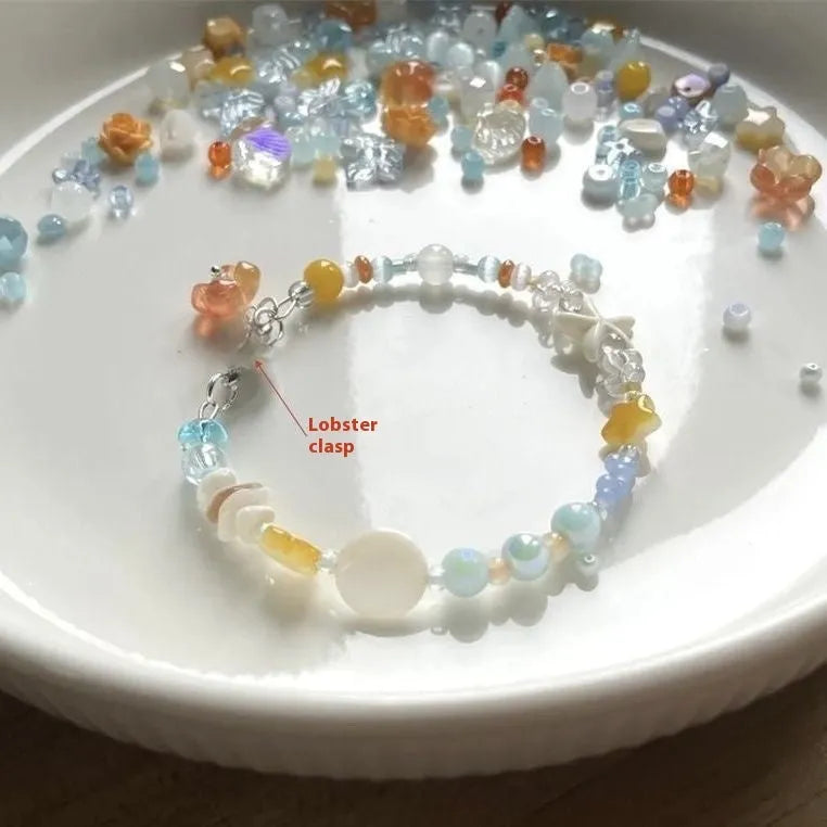 Women's orange summer bracelet with a diamond-shaped alloy centrepiece on a mixed-material band.