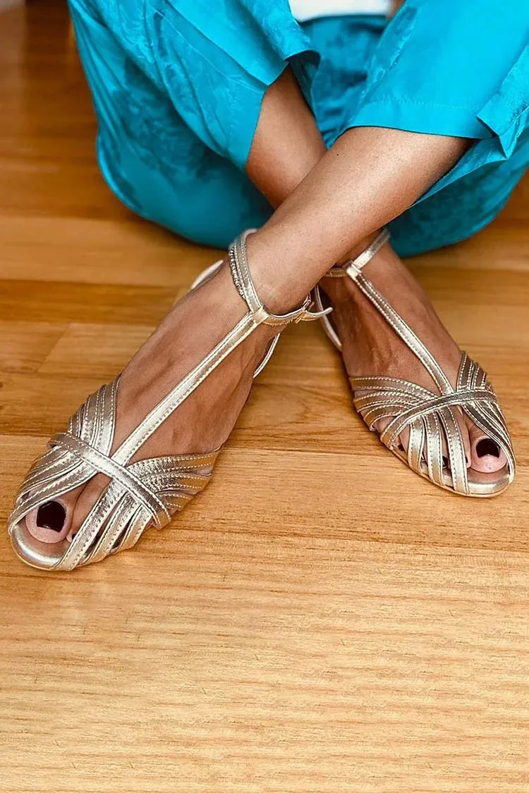 Gold flat peep toe ankle buckle hollow women's sandals with PU upper and rubber sole on a light background