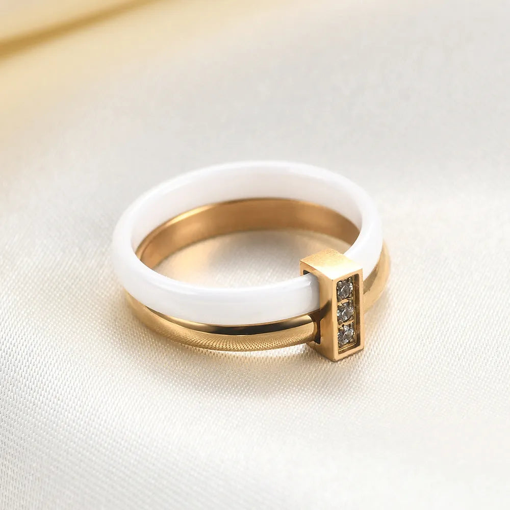 Close-up of a women's geometric ceramic ring with a 6mm wide band and glossy stitching detail, shown in a gold white electroplated finish.