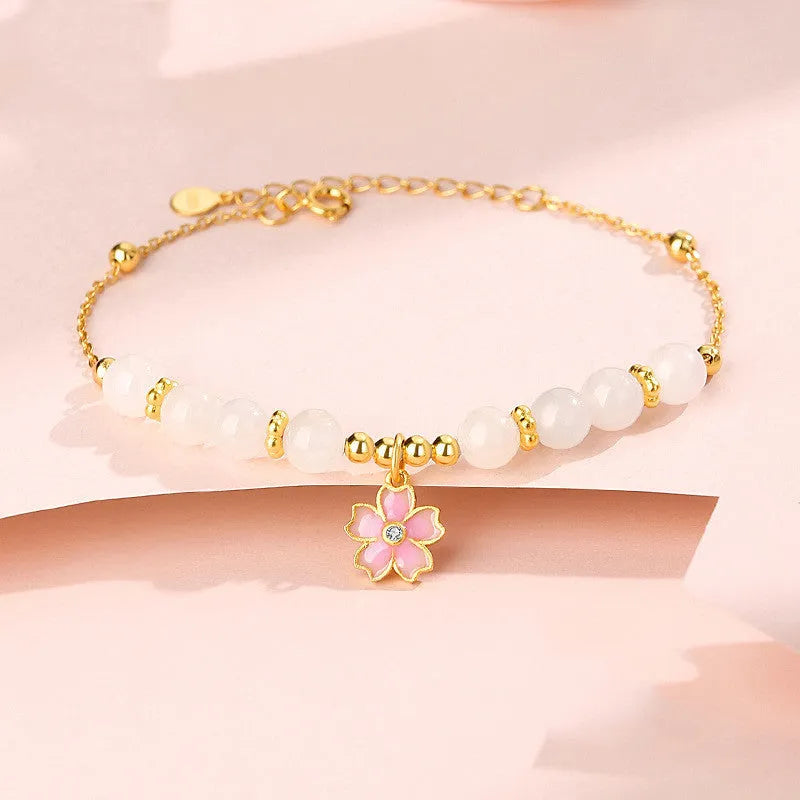 Pink women's bracelet with silver chain, Hetian jade beads, and a detailed cherry blossom flower pendant.