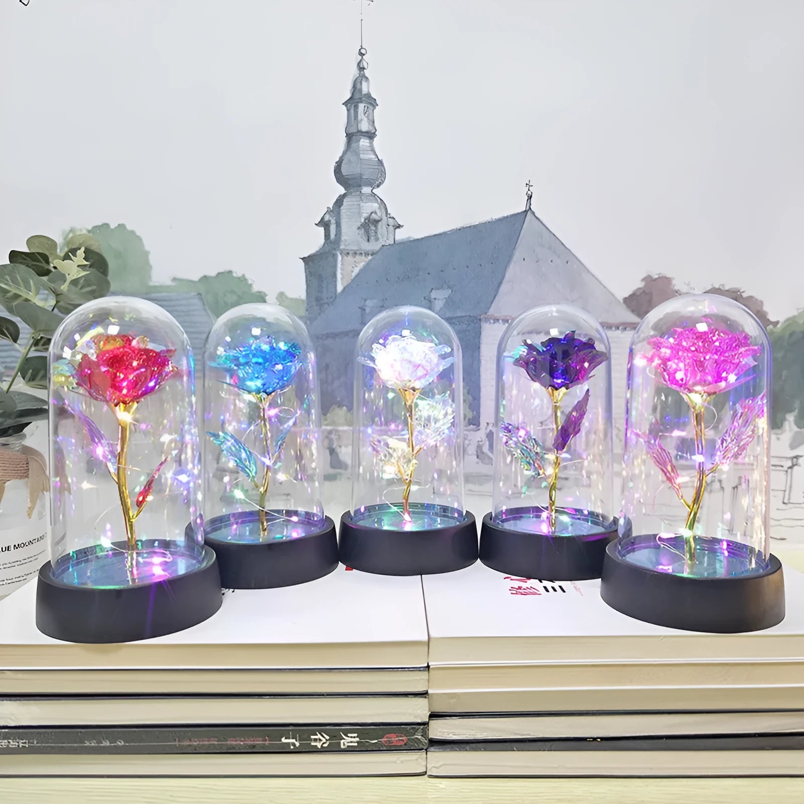 Small glass dome night lamp with plastic flowers on a black base, showing coloured light illumination.