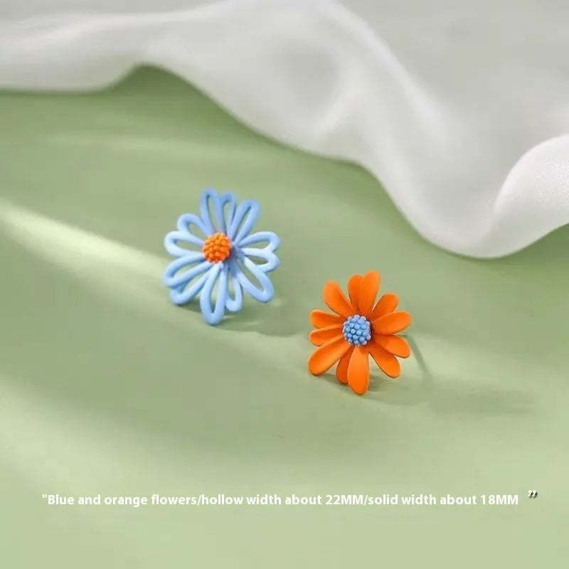 Close-up of colourful cartoon flower stud earrings in alloy on a white background.