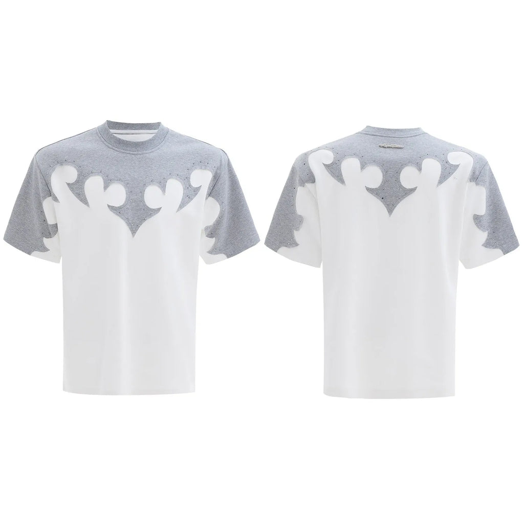 Close-up of a men's grey t-shirt with raised burnt flower embroidery and sparkling rhinestone details on the chest.