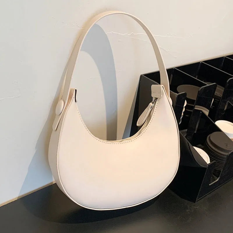 Retro dumpling-shaped women's shoulder bag in PU leather, shown in cream yellow colour.