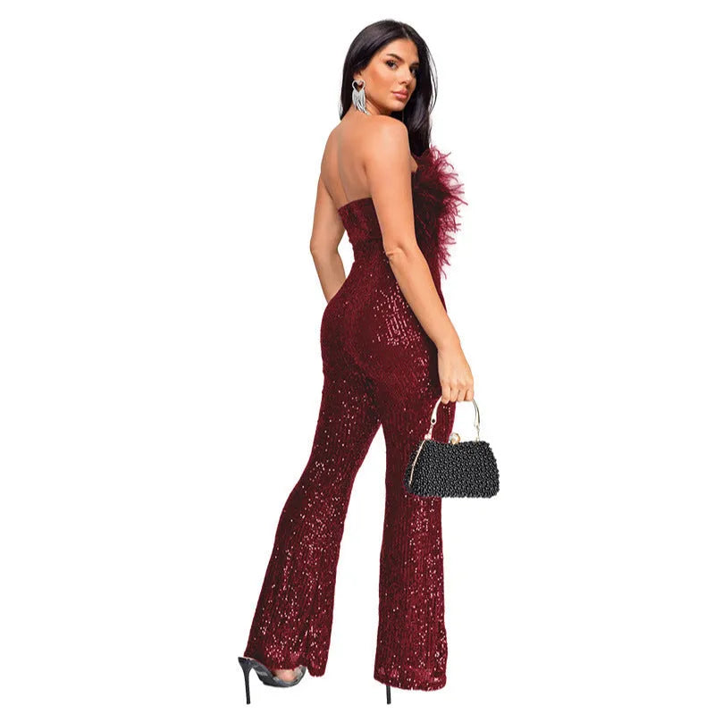 Woman wearing a black sleeveless backless jumpsuit with flared legs and sequin details.