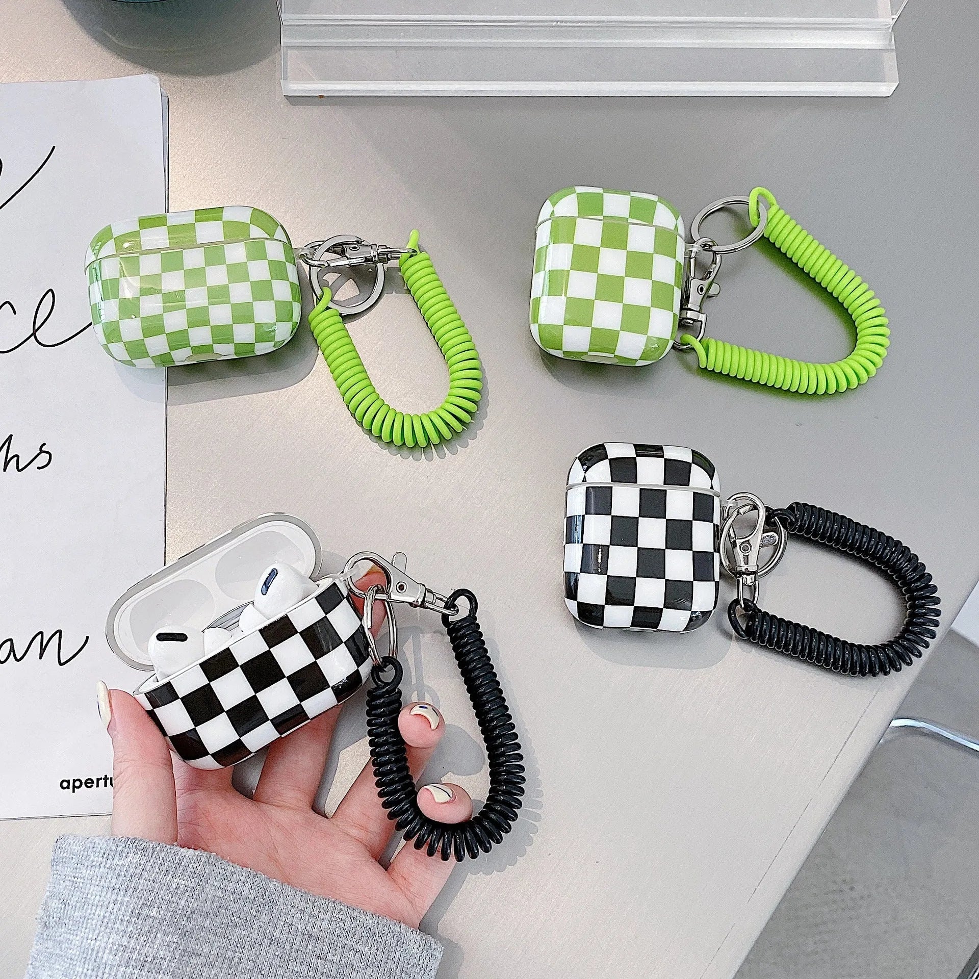 Black and green checkerboard pattern TPU protective sleeve for AirPods case with optional lanyard.