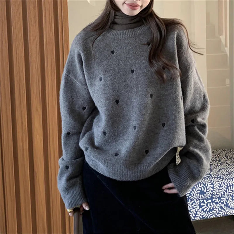Beige women's loose knit acrylic cardigan with embroidery on the front, featuring long sleeves and a crew neck.