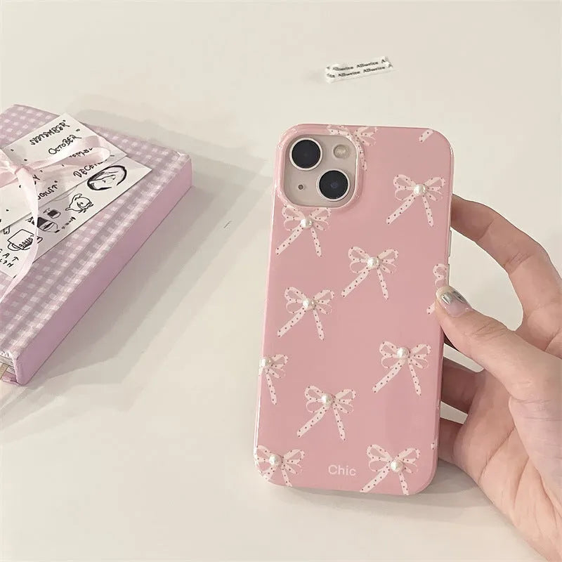 Pink soft TPU iPhone case with three-dimensional pearl dot bow, compatible with iPhone 11 to 15 Pro Max.
