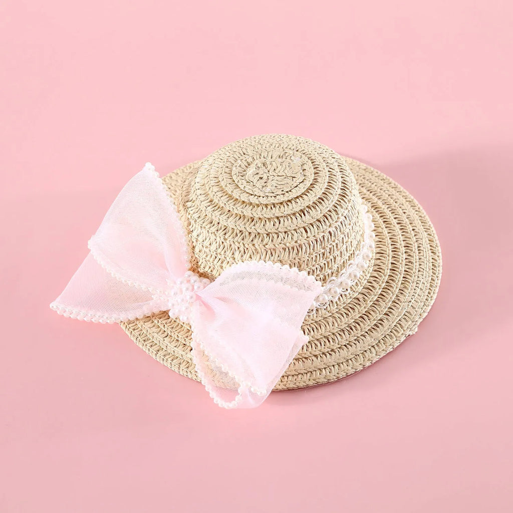 Cat wearing woven straw hat with pearl bow decoration in princess style