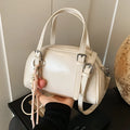 Women's square shoulder bag in PU leather with soft shell shape and optional ribbon pendant