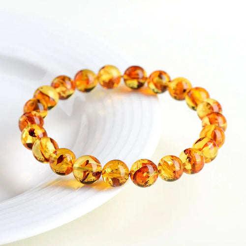 Natural yellow piebald amber geometric bracelet on a white background.