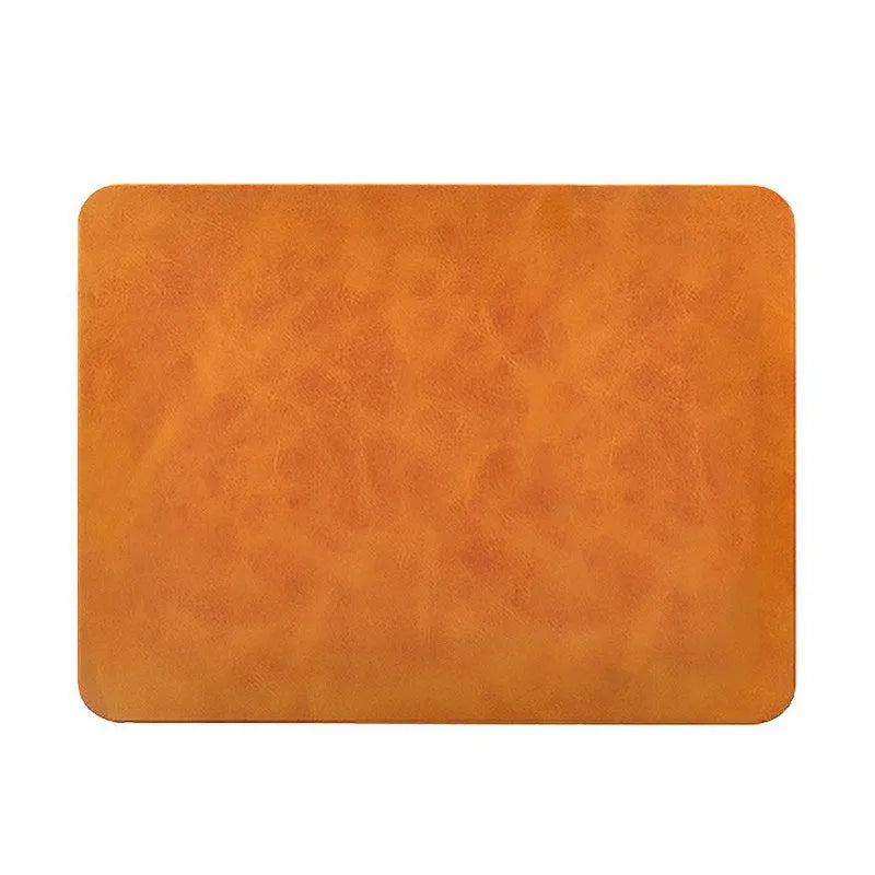 Brown leather desk mat with integrated wireless charging pad for mobile phones on a wooden desk.