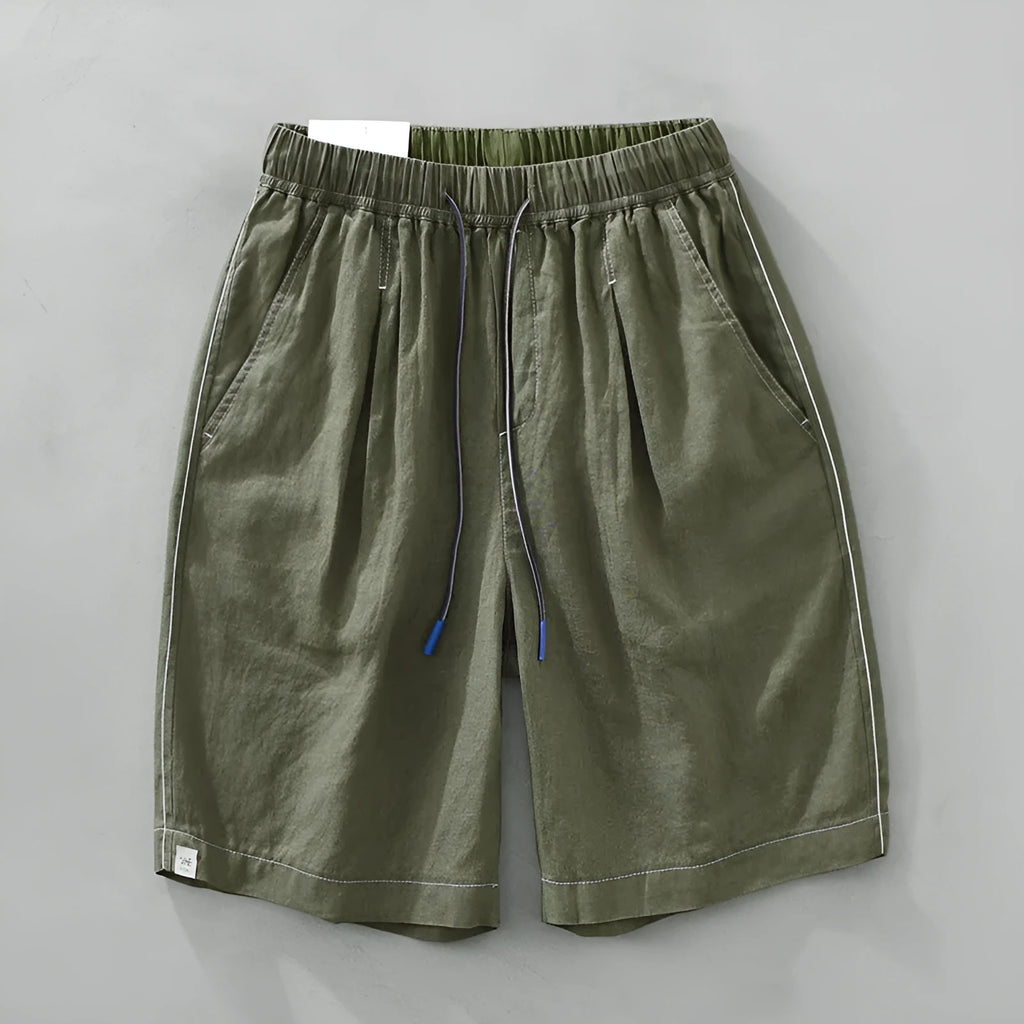 Men's loose fit linen shorts in green, showing straight drooping leg and drawstring waist.