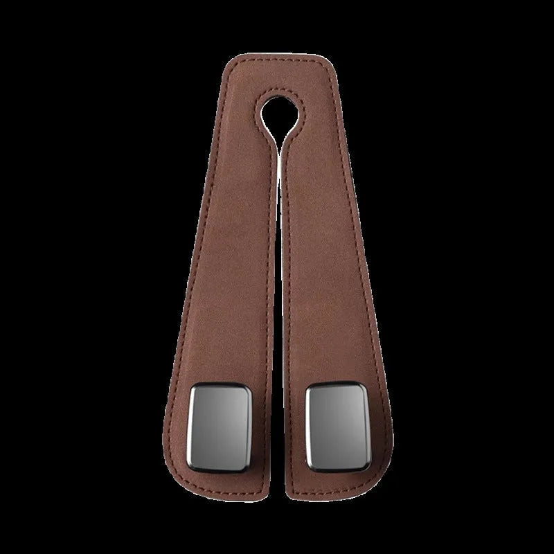 Alloy car seat hook clipped to headrest post in black, showing flip-down design for bag storage.