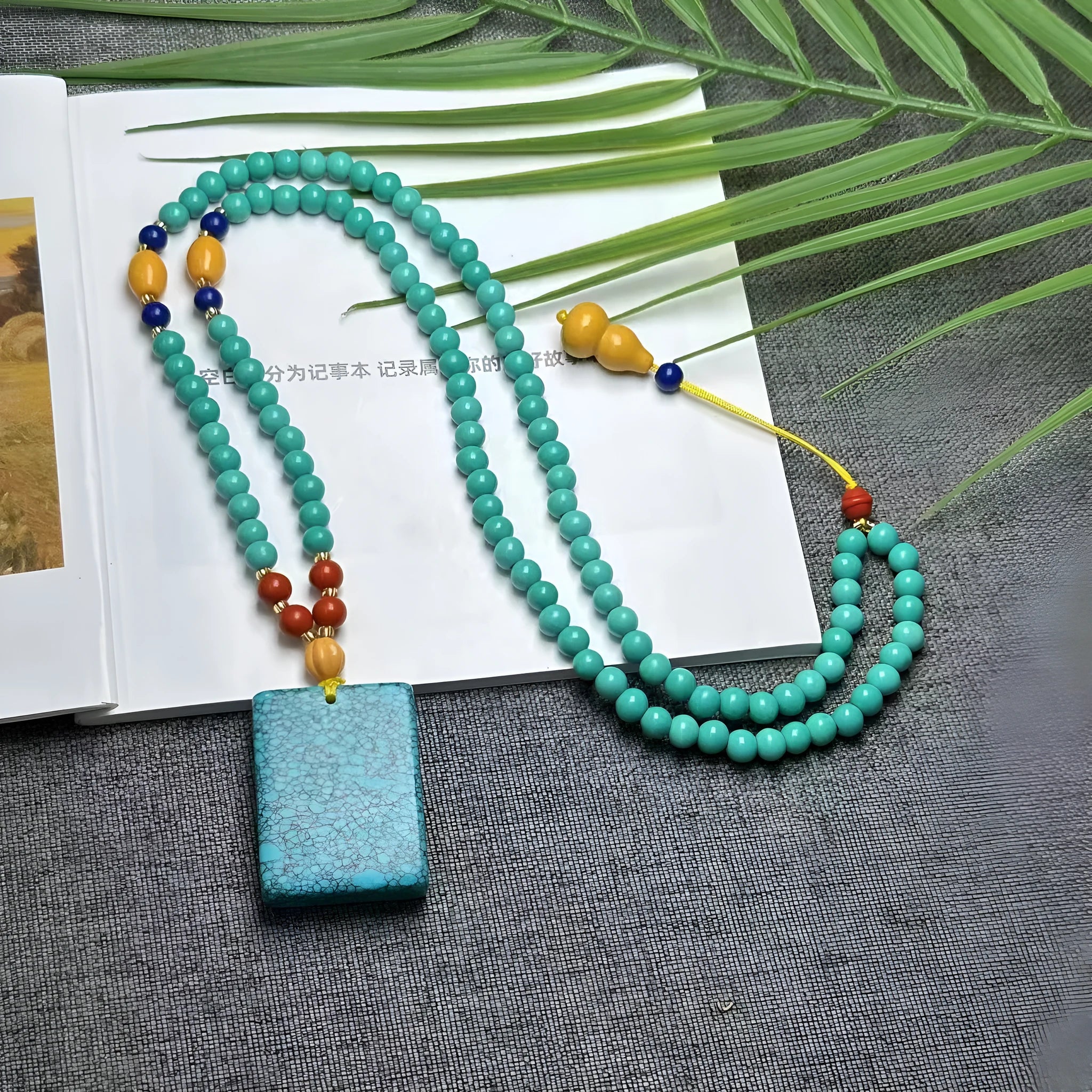 Turquoise necklace with a hand-woven stone mesh flower lucky pendant on a ball bead chain.