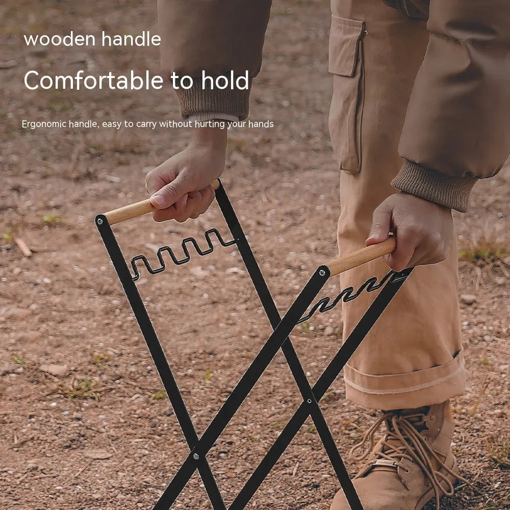 Outdoor black iron folding garbage storage hanger with wooden handle holding a bin bag.