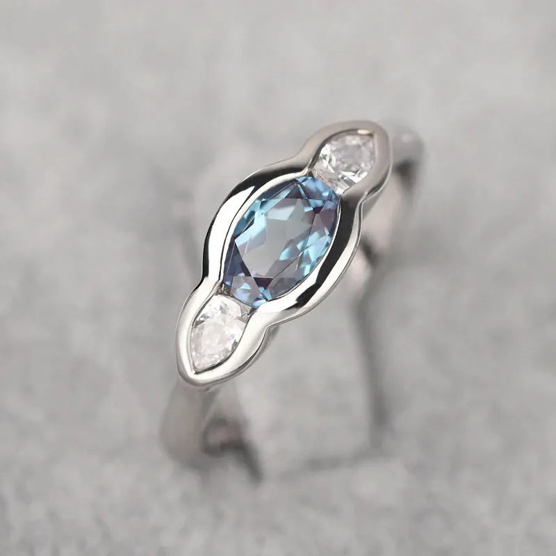 A geometric ellipse-shaped ring with an inlaid zircon, in a white gold colour finish.