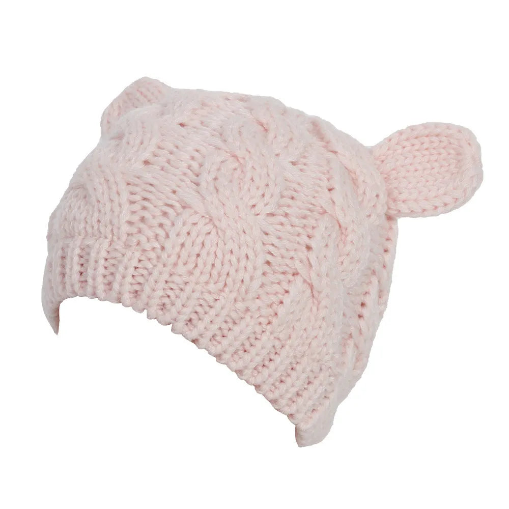 Hand-made knitted beanie with 3D cat ears in red wool, shown on a head.