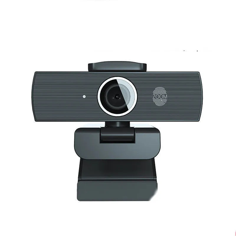 Black ABS plastic USB computer webcam with a detached magnetic privacy cover on a desk.