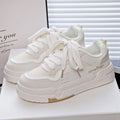 Beige children's lace-up trainers with cross straps over instep and thick rubber sole.