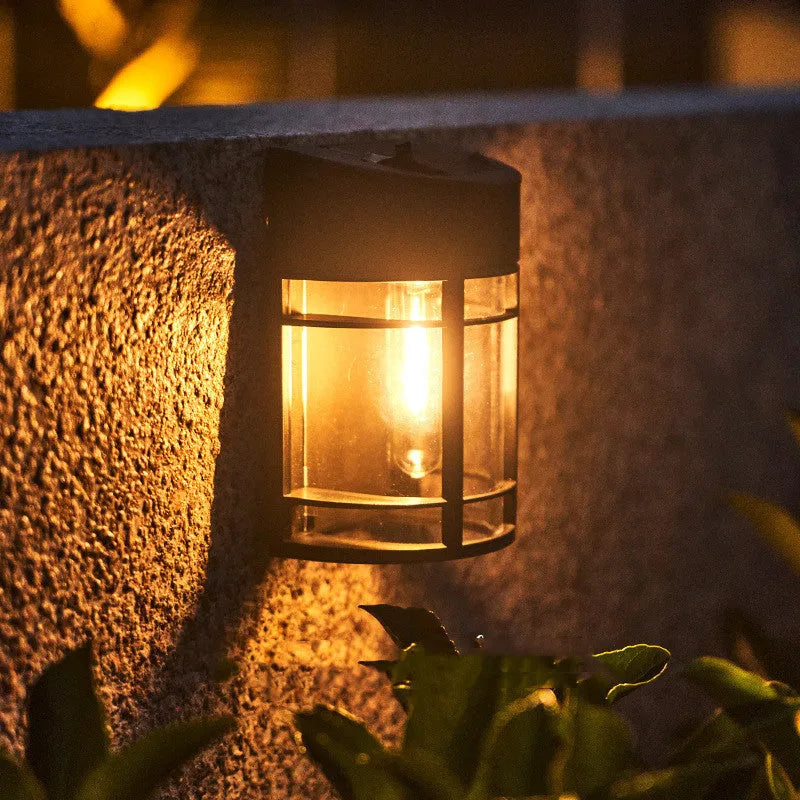 Solar-powered outdoor wall light with warm white LED, mounted on a garden wall.