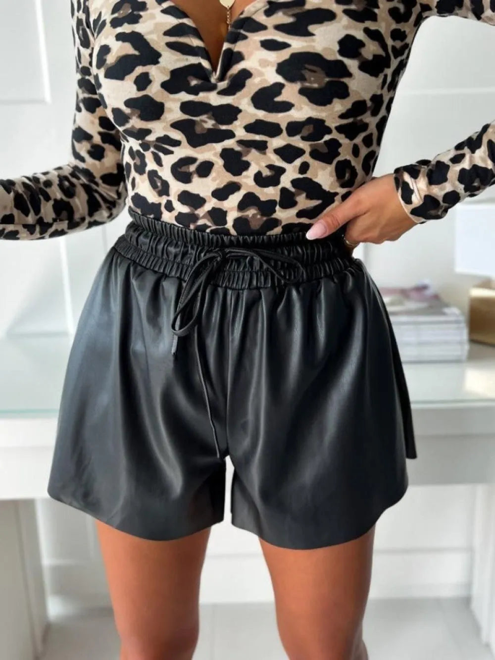 Black wide-leg women's shorts with a lace-up drawstring waist and a textured PU leather appearance.