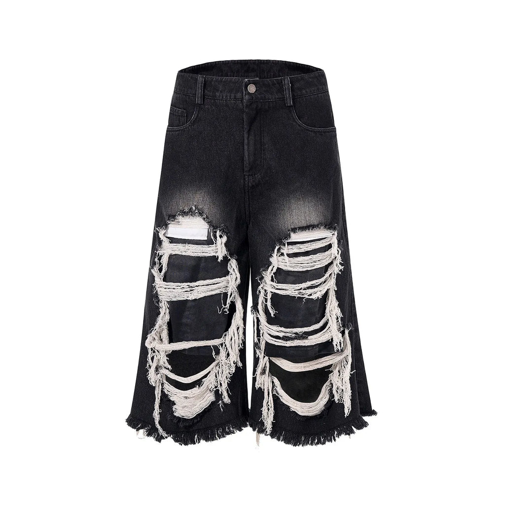 Black wide leg cropped jeans with distressed patch details and a mid-high waist.