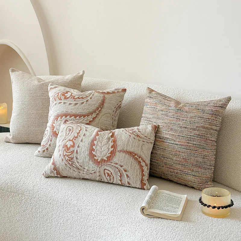 American-style jacquard paisley pattern sofa cushion cover in an amber colour on a grey sofa.