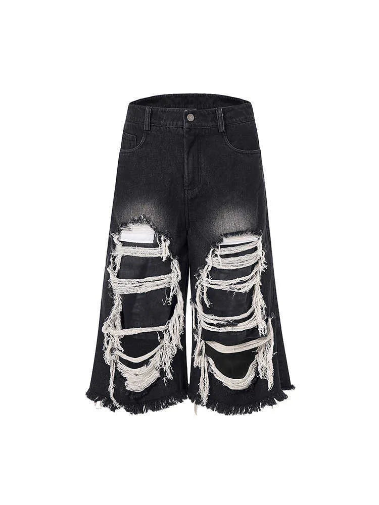 Black wide leg cropped jeans with distressed patch details and a mid-high waist.