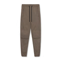 Man wearing dark grey loose-fit fitness trousers with tied ankle cuffs, suitable for gym training.