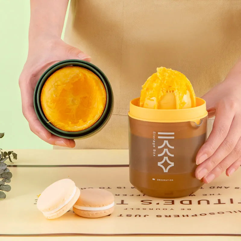 Green manual citrus juicer with lid, showing its compact size and simple design for squeezing lemons and oranges.