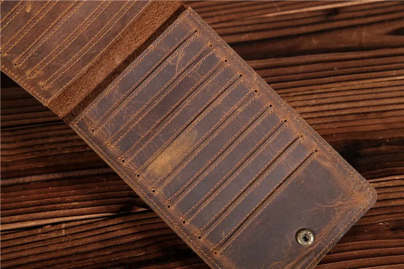 Slim brown cowhide men's wallet open to show 18 card slots and a phone compartment.