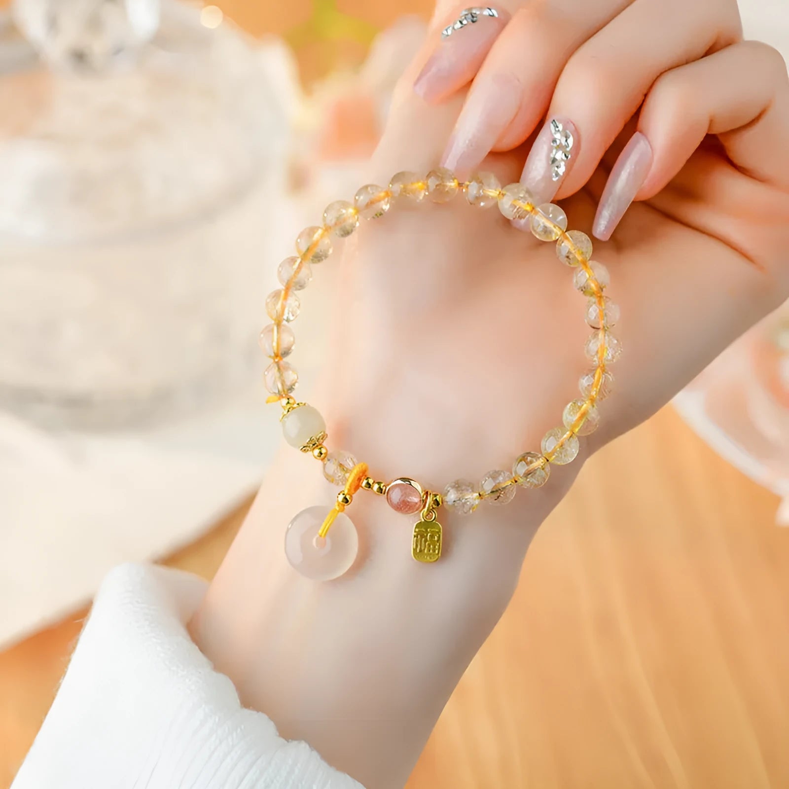 Gold rutilated quartz bracelet with safety buckle and geometric blessing card pendant.