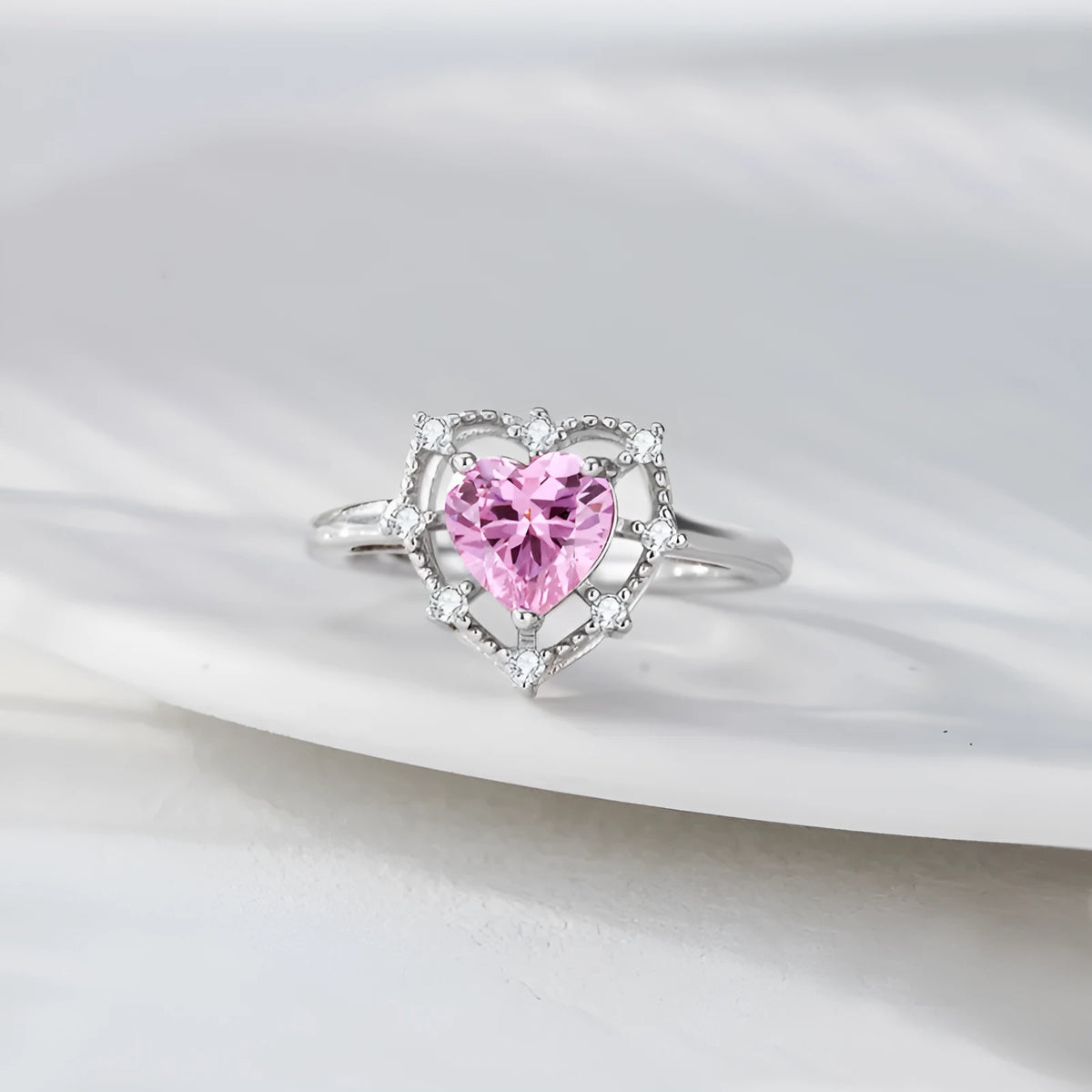 Silver heart-shaped ring with inlaid zircon and hollow-out band in white gold colour