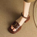 Women's black leather sandals with a thick rubber sole and buckle fastening.