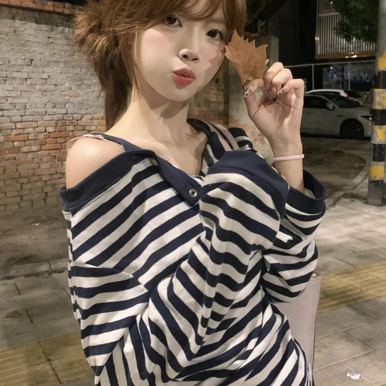 Dark blue women's oversized long-sleeved t-shirt with embroidery and stripe details on a hanger.