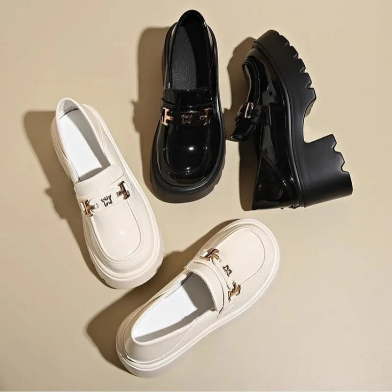 Black slip-on leather shoes with a chunky square heel and a skull pattern on the upper.