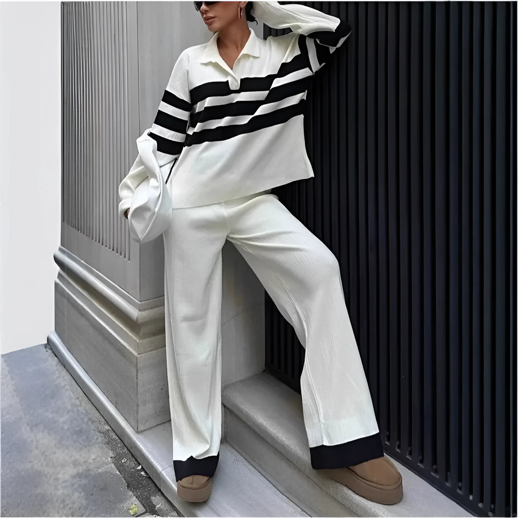Woman wearing a black and white striped long-sleeve polo shirt and matching black casual trousers from a two-piece knit set.