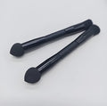 Black double-headed concealer brush with sponge end and tapered brush end on wooden handle