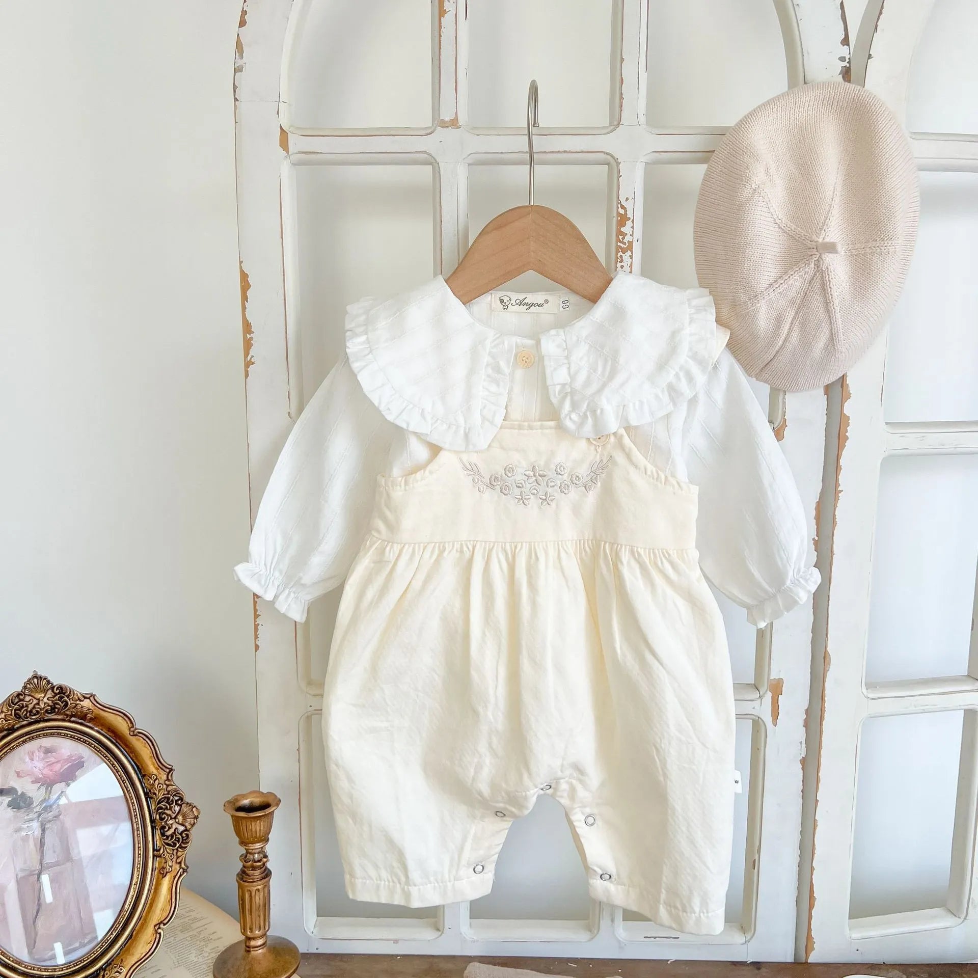 Apricot coloured baby girl's cotton romper with white top, adjustable suspenders, and mid-waist trousers.