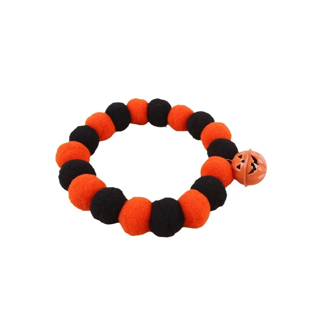 Orange Halloween cat collar with a pumpkin graphic and text, showing the adjustable clasp.
