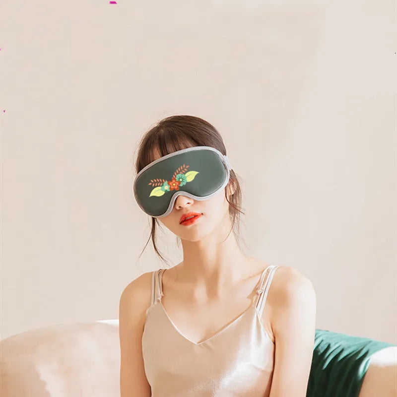 Green portable steam sleep massage goggles with suede shell on a grey background.