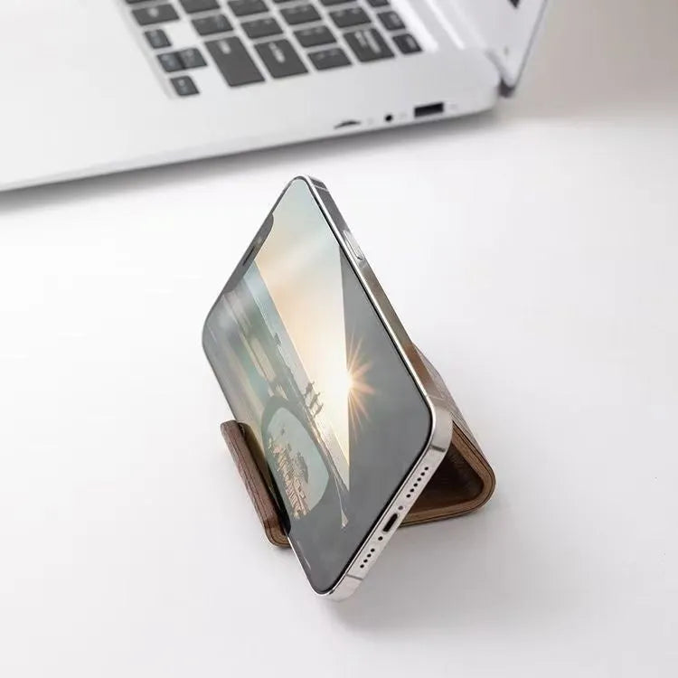 Walnut wood mobile phone bracket on a desk holding a smartphone upright for handsfree viewing