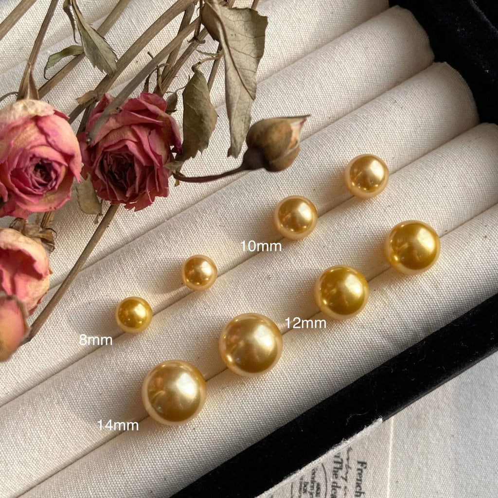 Geometric large pearl stud earrings with an eight-point star detail on a silver setting.