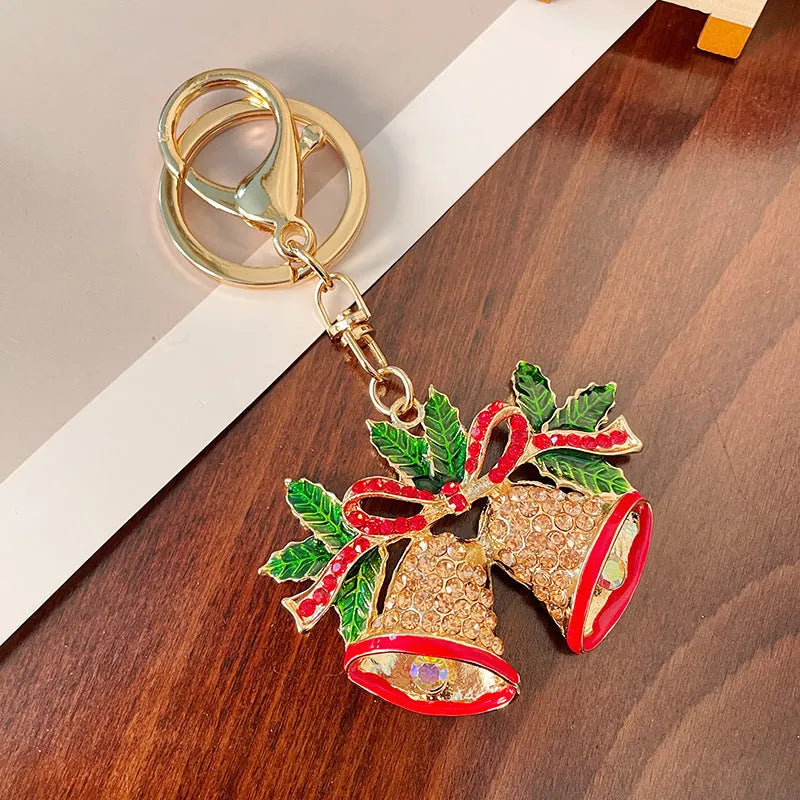 Diamond studded metal Christmas bell keychain in European style on a white background