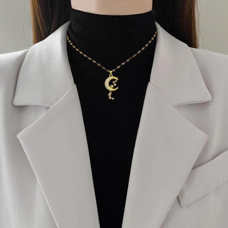 Geometric moon pendant necklace with tassel on a stainless steel chain, showing copper metal tone.