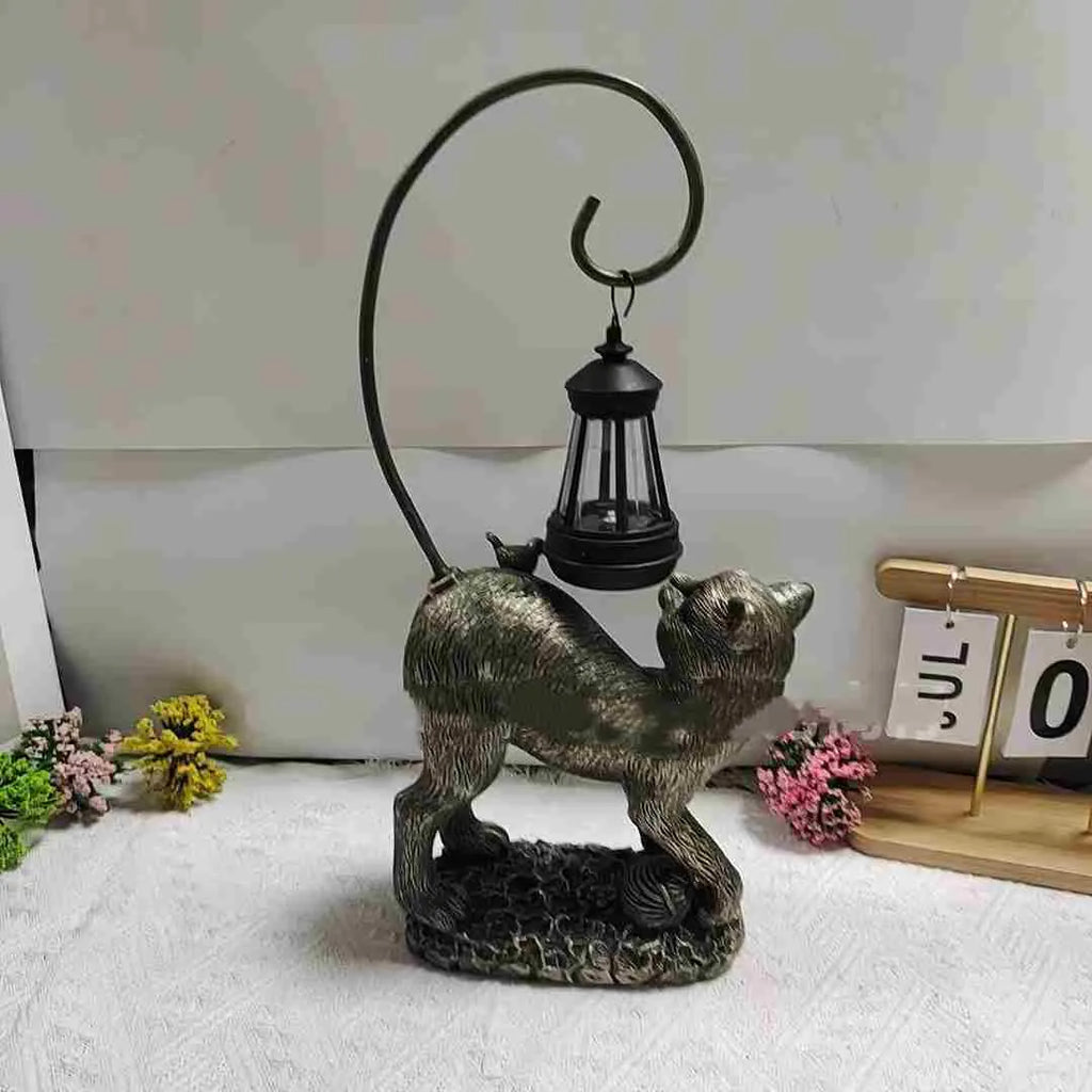 Bronze resin cat solar garden lamp on a garden path, outdoor decoration